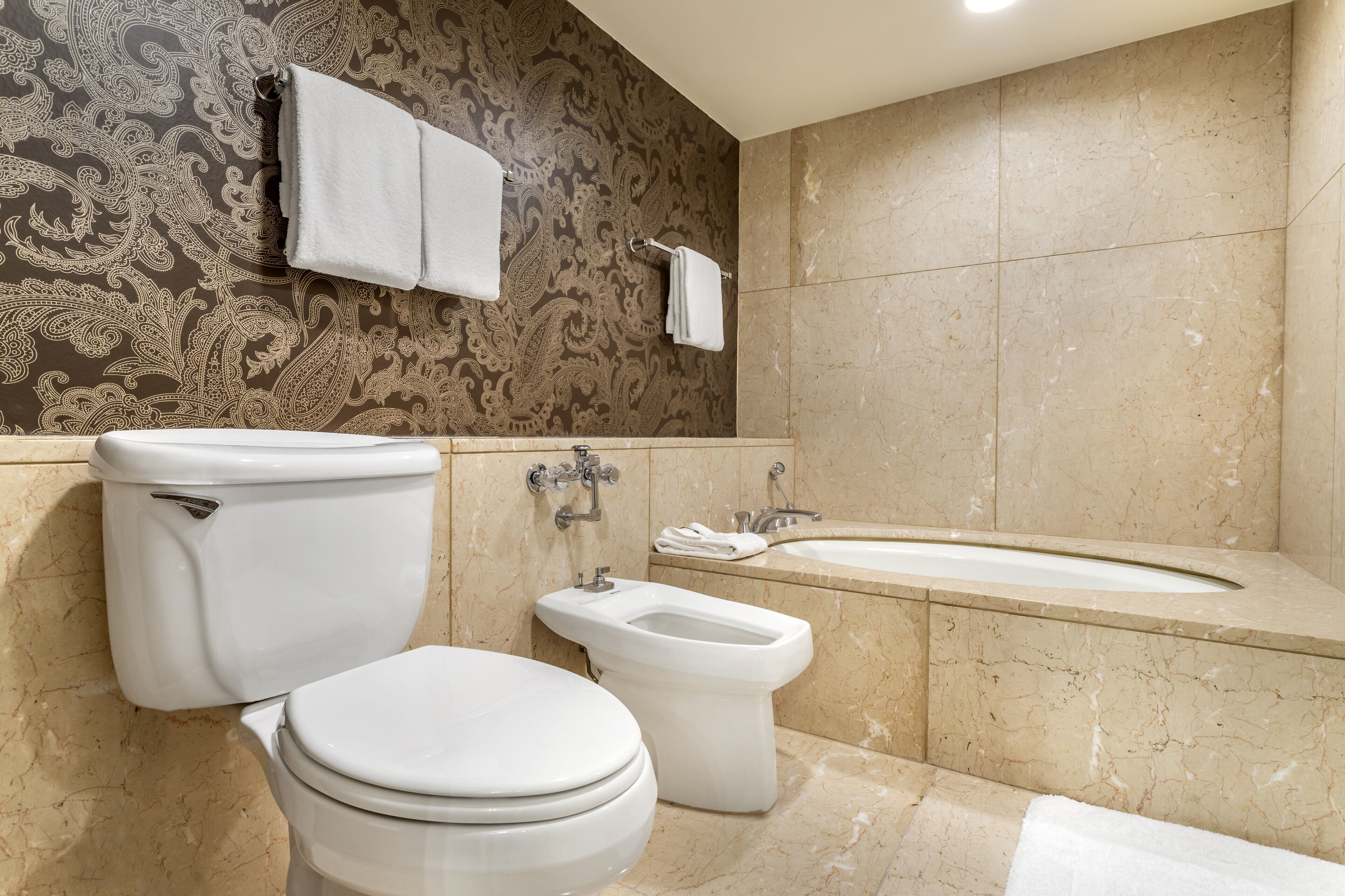 A bathroom with a toilet, bidet, and bathtub.