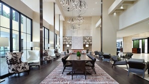 A spacious dining area with a long table, multiple chairs, and a central plant.