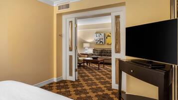 A hotel room with a bed, a TV, a desk, and a sofa.