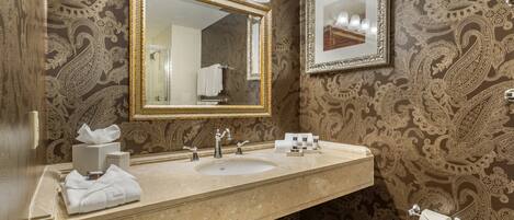 A bathroom with a large mirror, two sinks, and a towel rack.