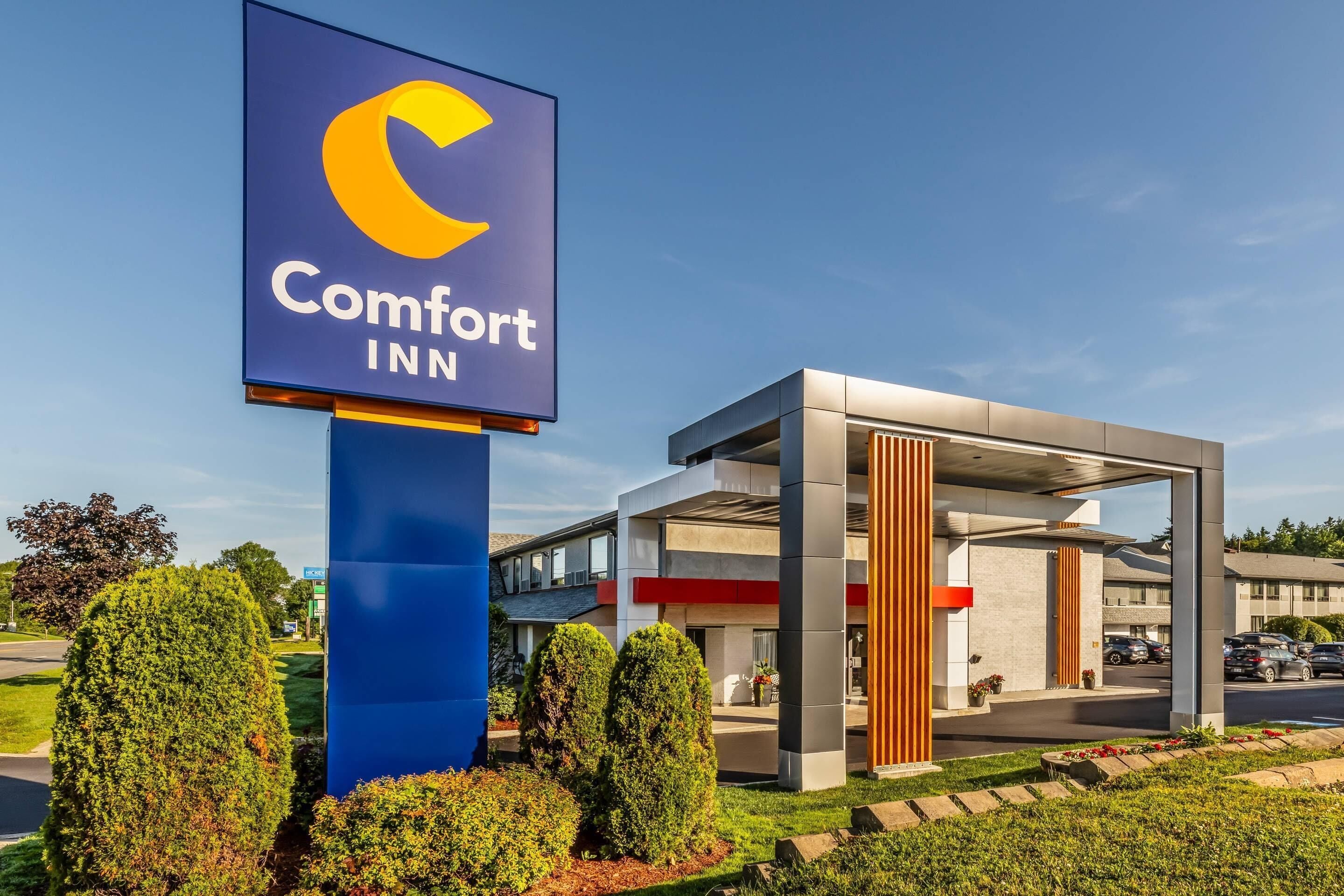 A Comfort Inn sign and a modern building with a covered parking area.