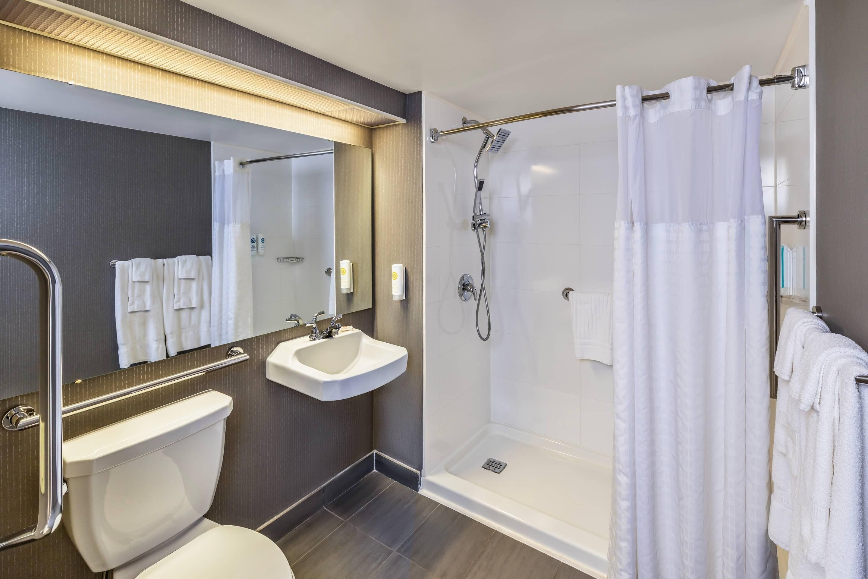 Un baño moderno con inodoro, lavamanos y ducha.