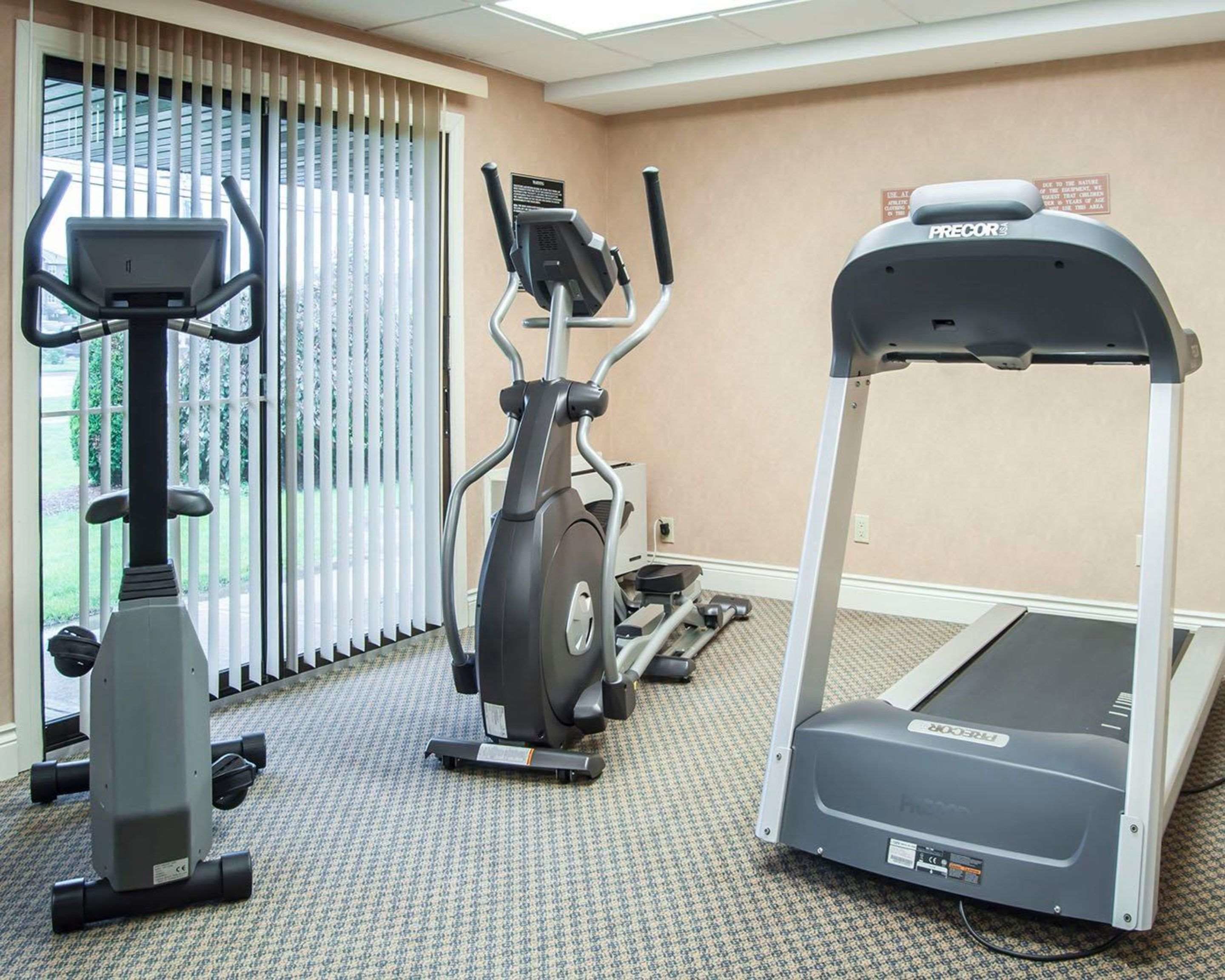 A gym with stationary bikes, an elliptical trainer, and a treadmill.