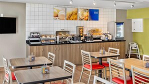 A modern breakfast area with a counter, seating, and a TV. - Comfort Inn (Fredericton)