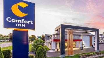 Ett Comfort Inn-hotell med ett väl synligt skylt, modern arkitektur och en vackert anlagd entré.