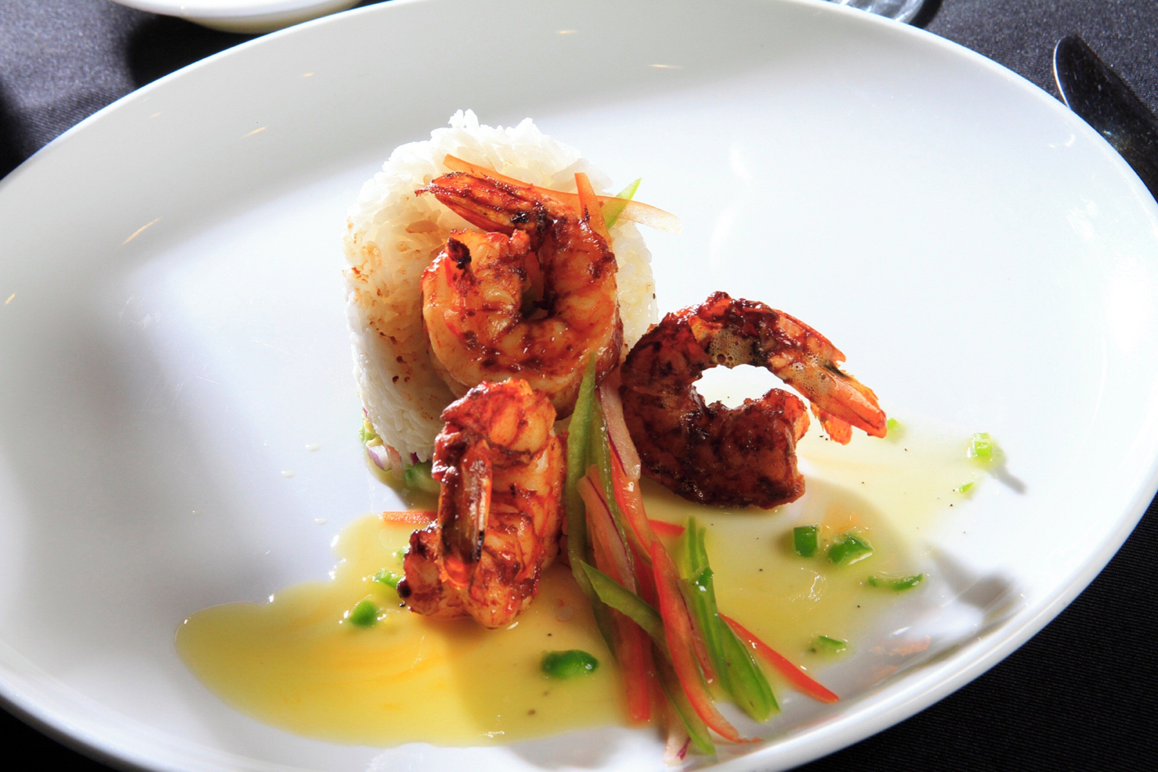 Un plato de arroz, camarones y verduras.