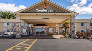 L’entrée d’un hôtel Comfort Inn, avec un ciel dégagé, un parking et un panneau indiquant une hauteur libre de 11 pieds et 5 pouces.