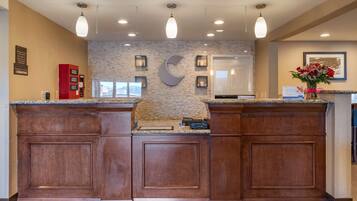 A reception area with a stone wall, wooden cabinets, and pendant lighting.