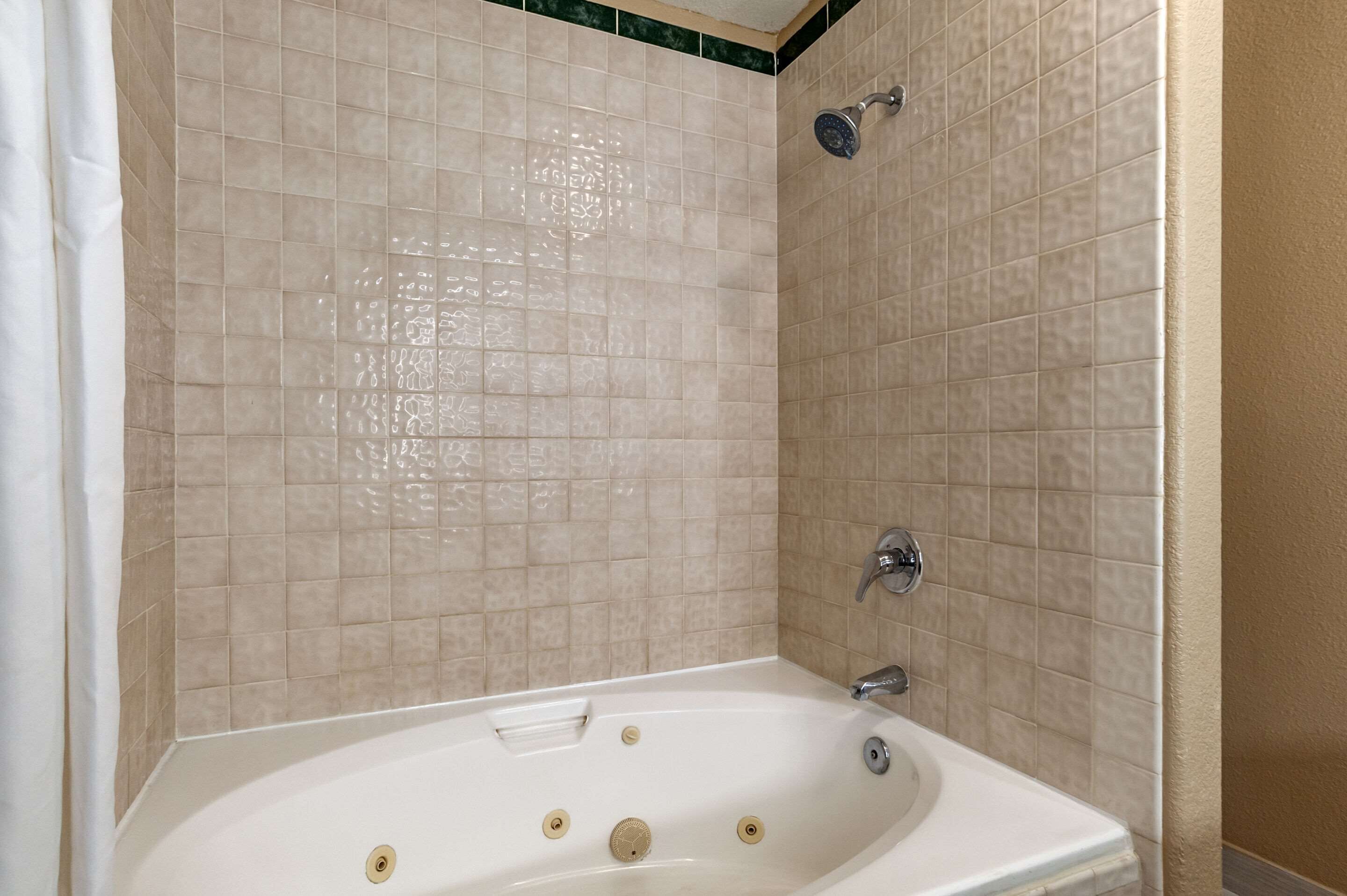 A bathroom with a bathtub, a shower, and a sink.
