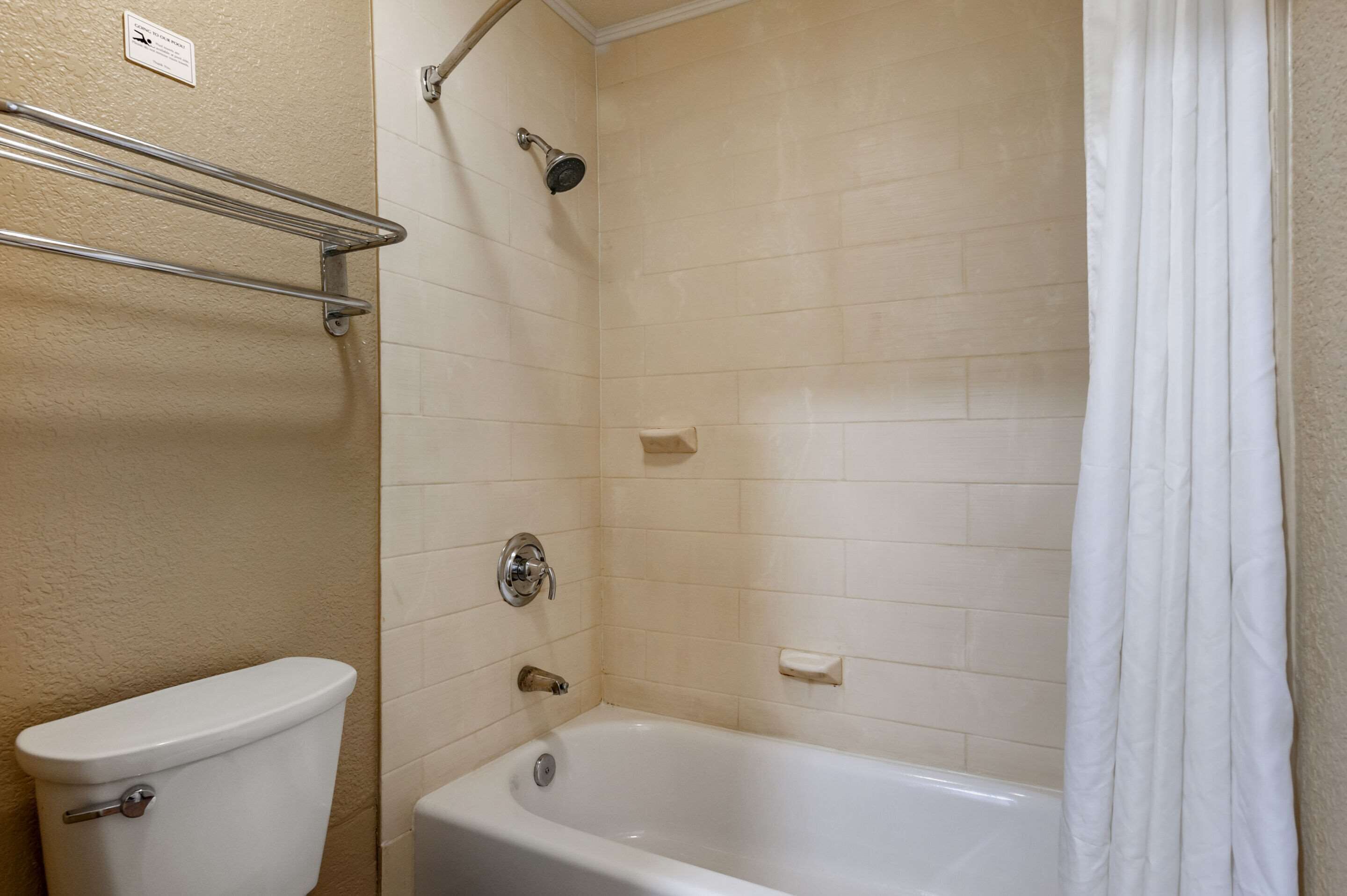A bathroom with a toilet, a shower, and a bathtub.