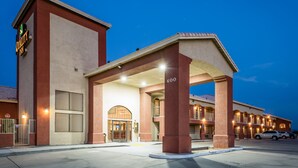 A hotel with a prominent entrance, a covered area, and a parking lot.