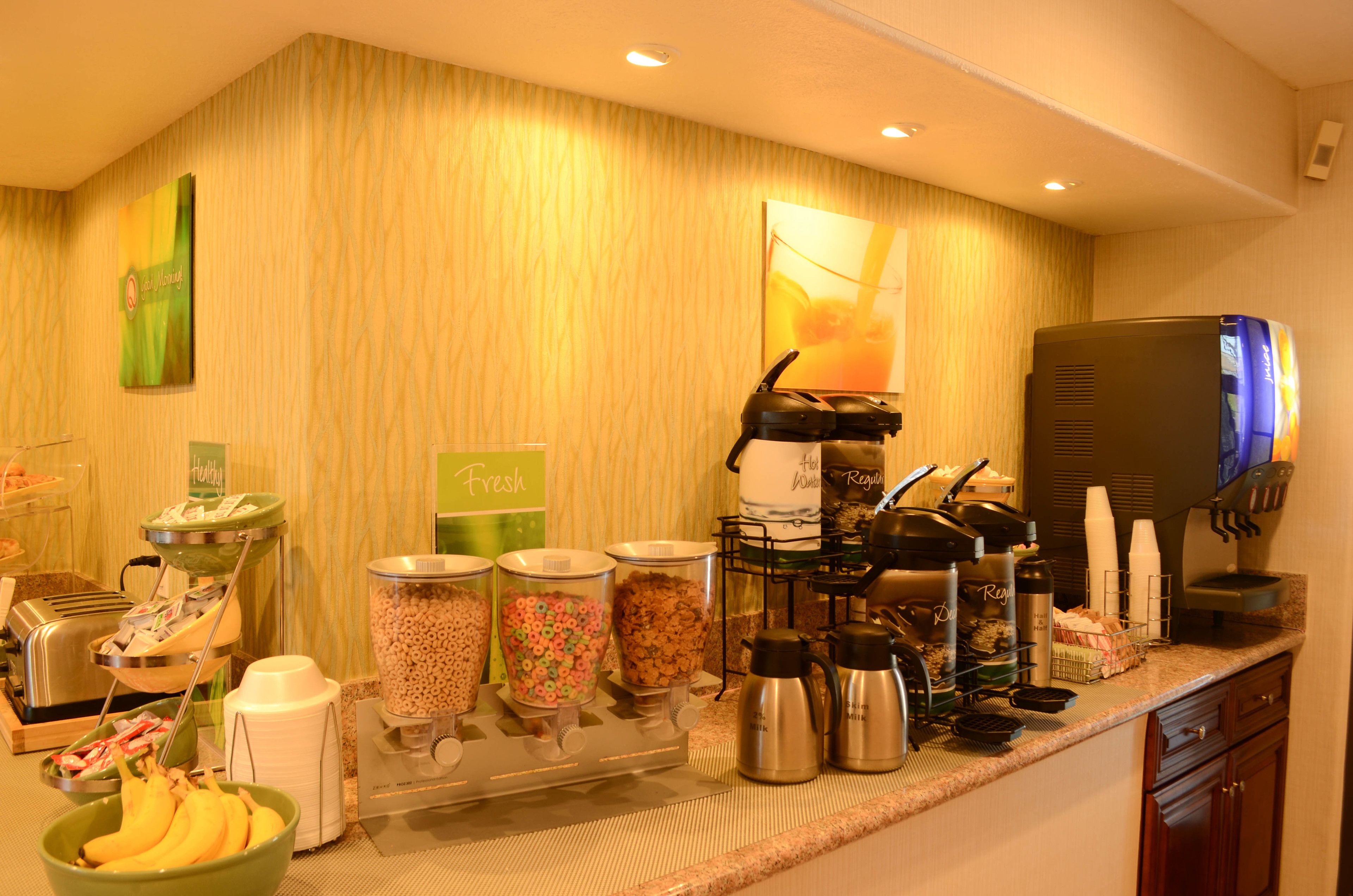 A breakfast buffet with cereal, fruits, and coffee options.