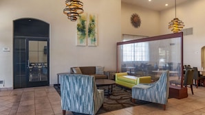 A spacious lobby with a seating area, a large window with curtains, and a door leading to a balcony. - Quality Inn Blythe I-10 (Blythe)