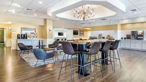 A spacious, well-lit kitchen area with modern appliances, a central island with bar stools, and a chandelier. - Best Western Springfield Hotel (Springfield)
