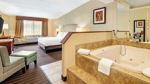 A hotel room with a bed, a sitting area, a bathroom with a bathtub, and a large mirror. - Best Western Springfield Hotel (Springfield)