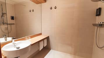Ein modernes Badezimmer mit Waschbecken, Spiegel und Dusche.