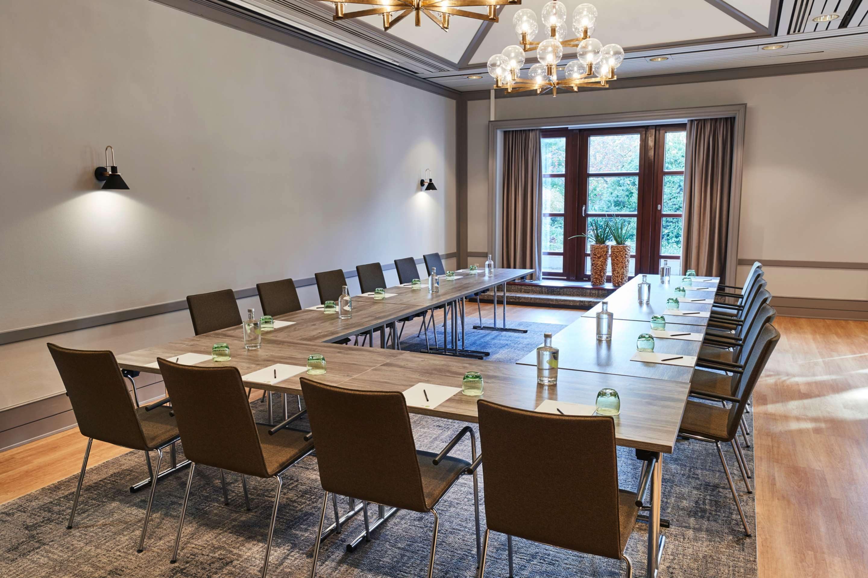 Ein Konferenzraum mit einem langen Tisch, Stühlen und einer Kristallleuchtre.