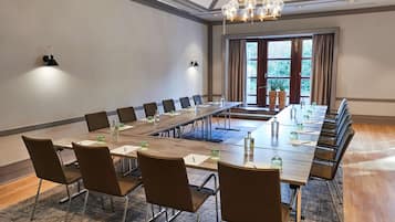 Ein Konferenzraum mit einem langen Tisch, Stühlen und einer Kristallleuchtre.