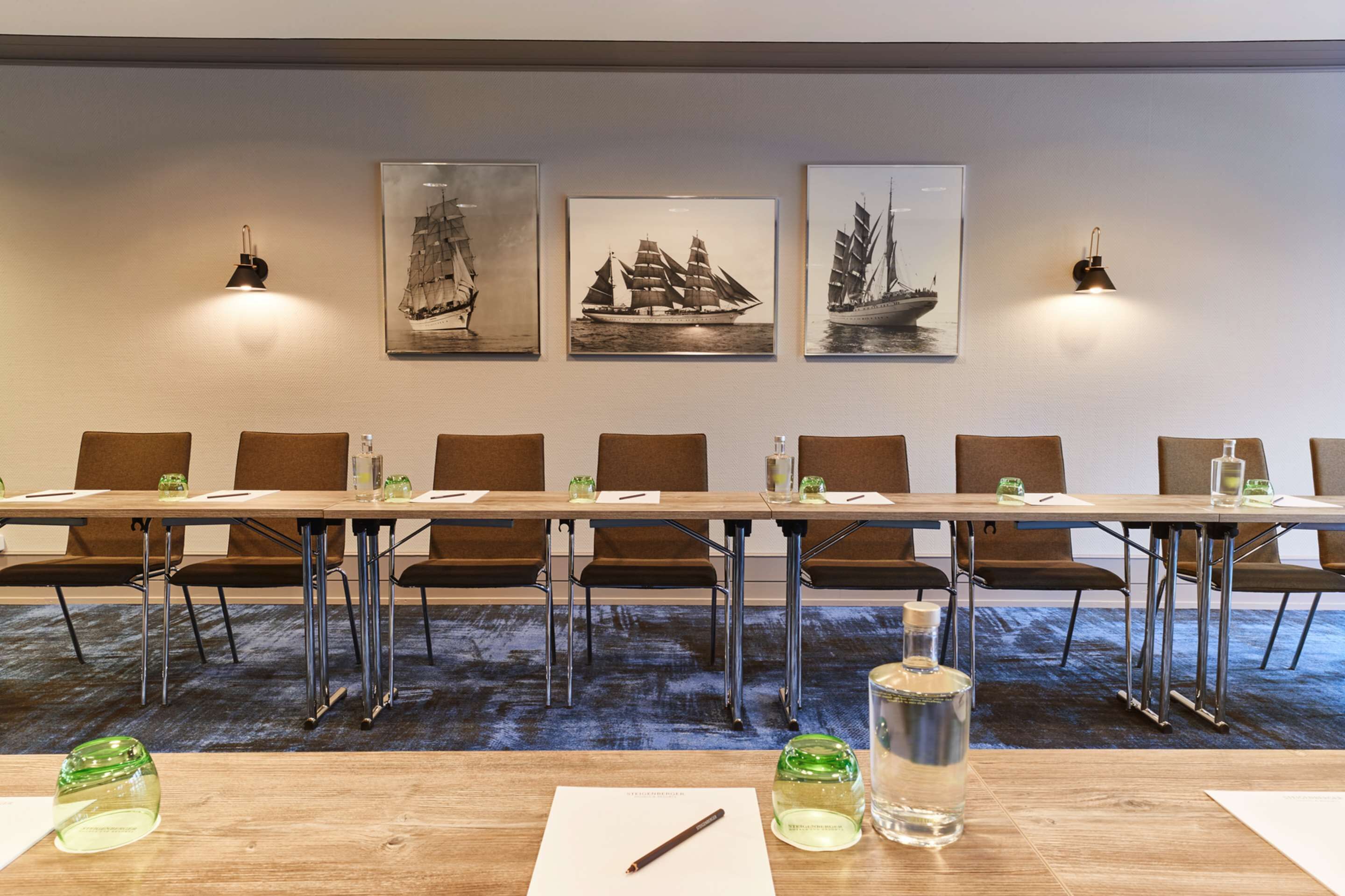 A conference room with a long table, chairs, and artwork on the wall.