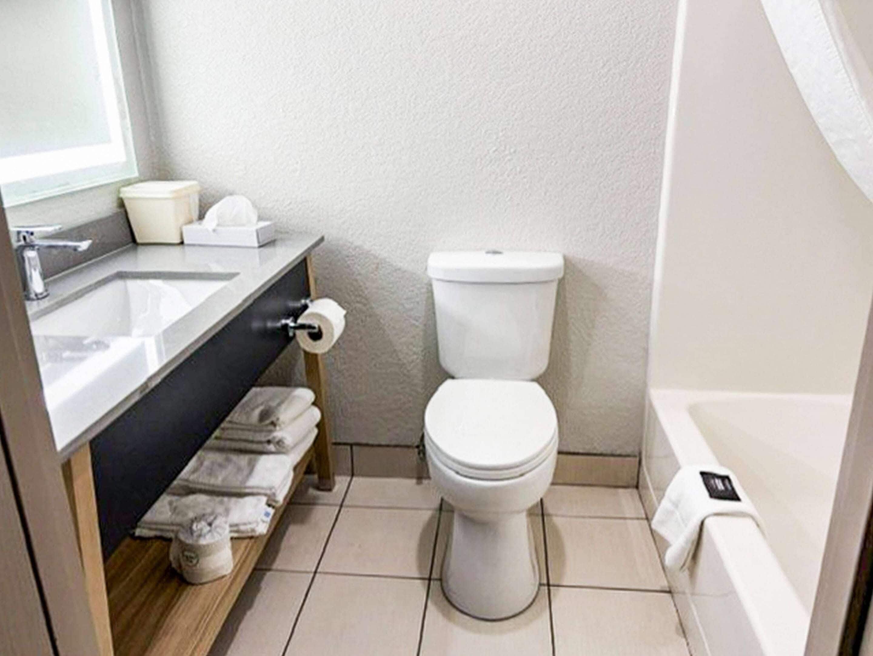 A bathroom with a toilet, sink, and bathtub.