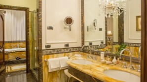 Un baño lujoso con dos lavamanos, un espejo grande y una araña.