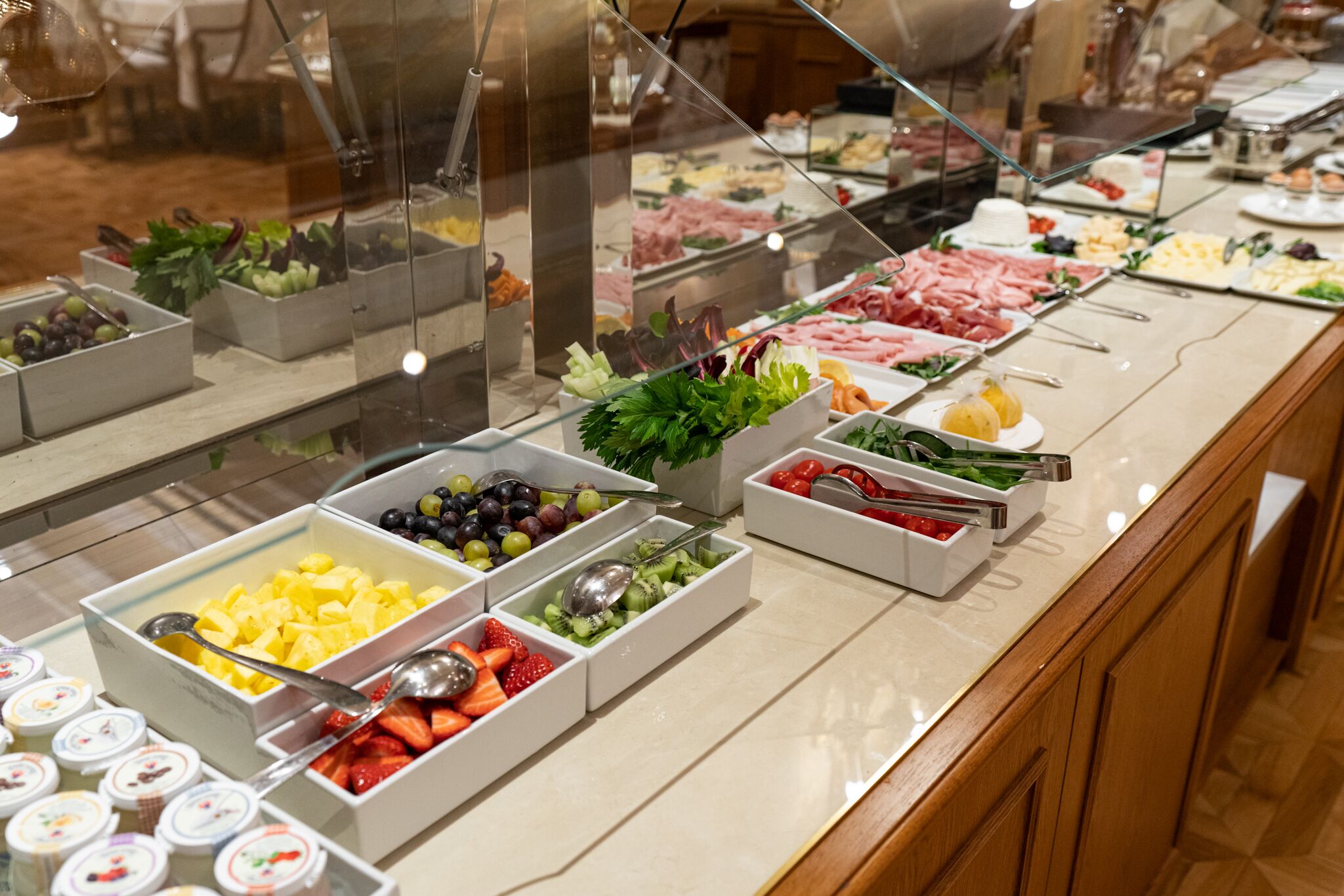 En buffet med forskellige retter, herunder frugt, grøntsager og kød.