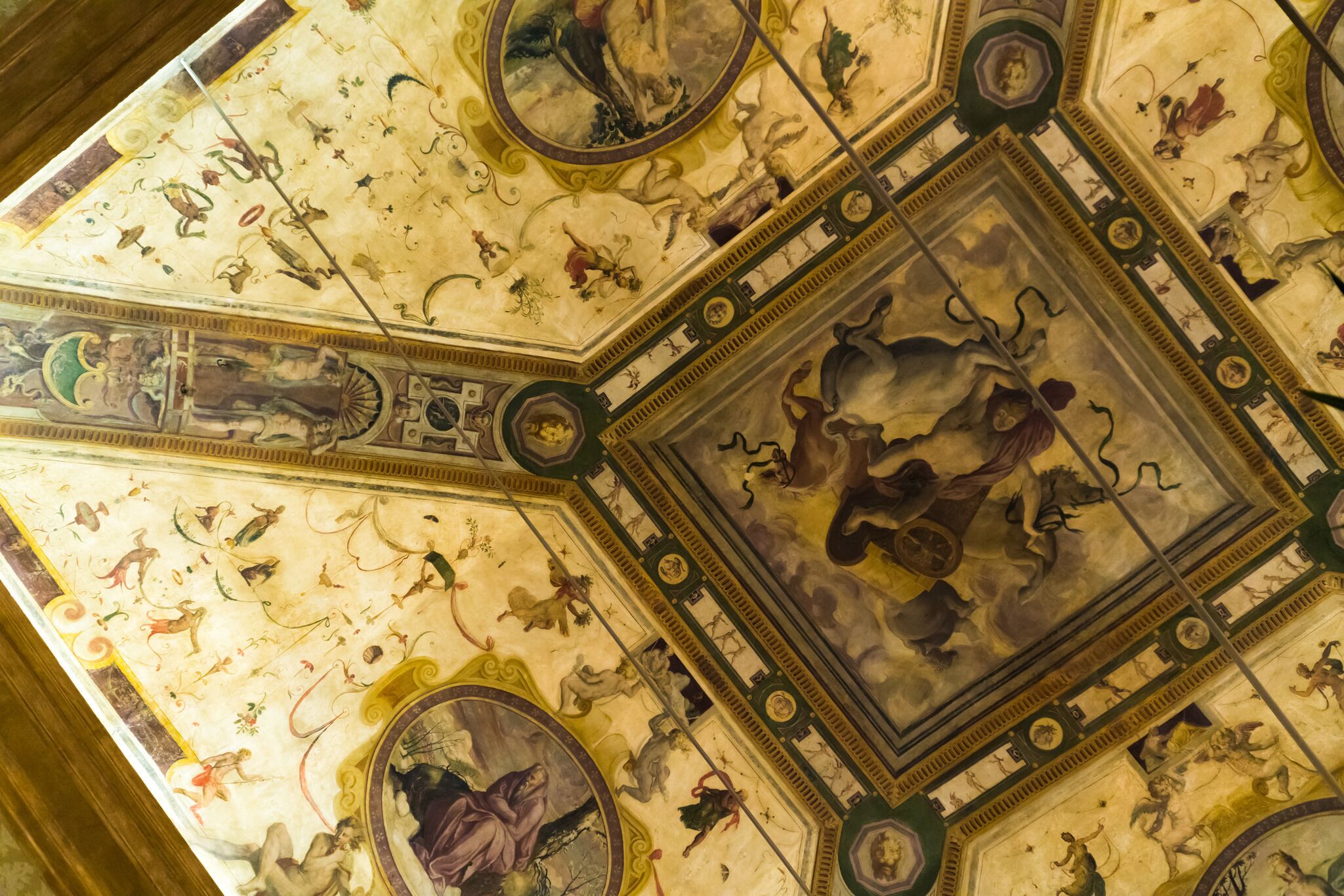Een gedetailleerd plafond met ingewikkelde fresco's en architecturale versieringen.