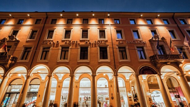 The Grand Hotel Majestic facade with multiple arches and illuminated signage.