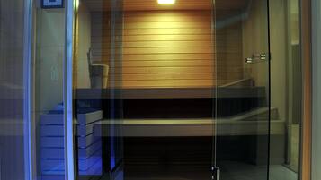 Un ascensor moderno con puertas de cristal, un panel de pared de madera y un tablero de control a la izquierda.