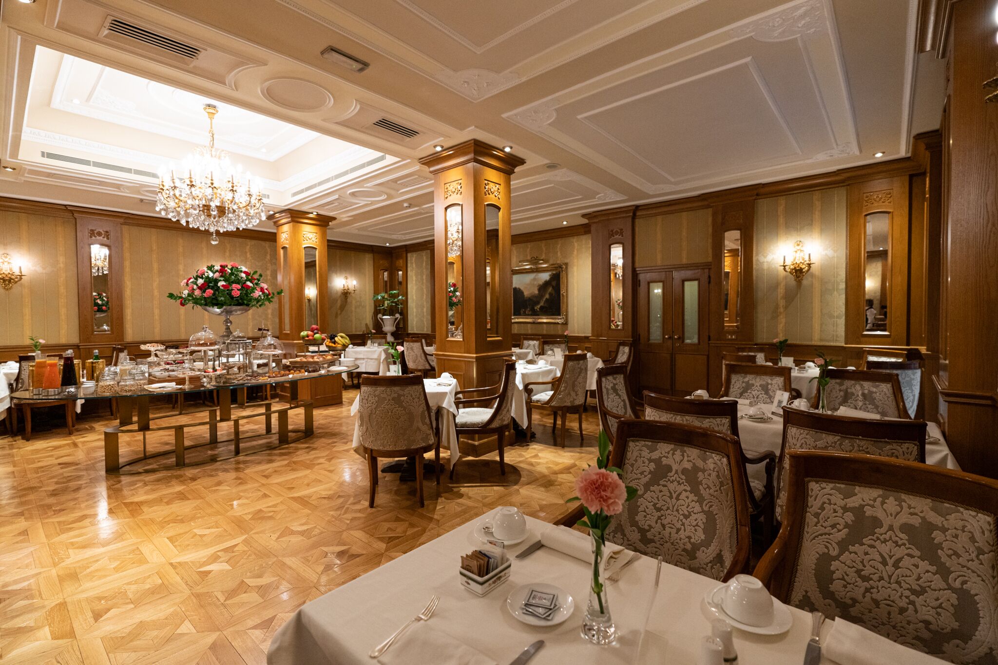 Un comedor formal con paneles de madera, candelabros y una mesa de buffet.