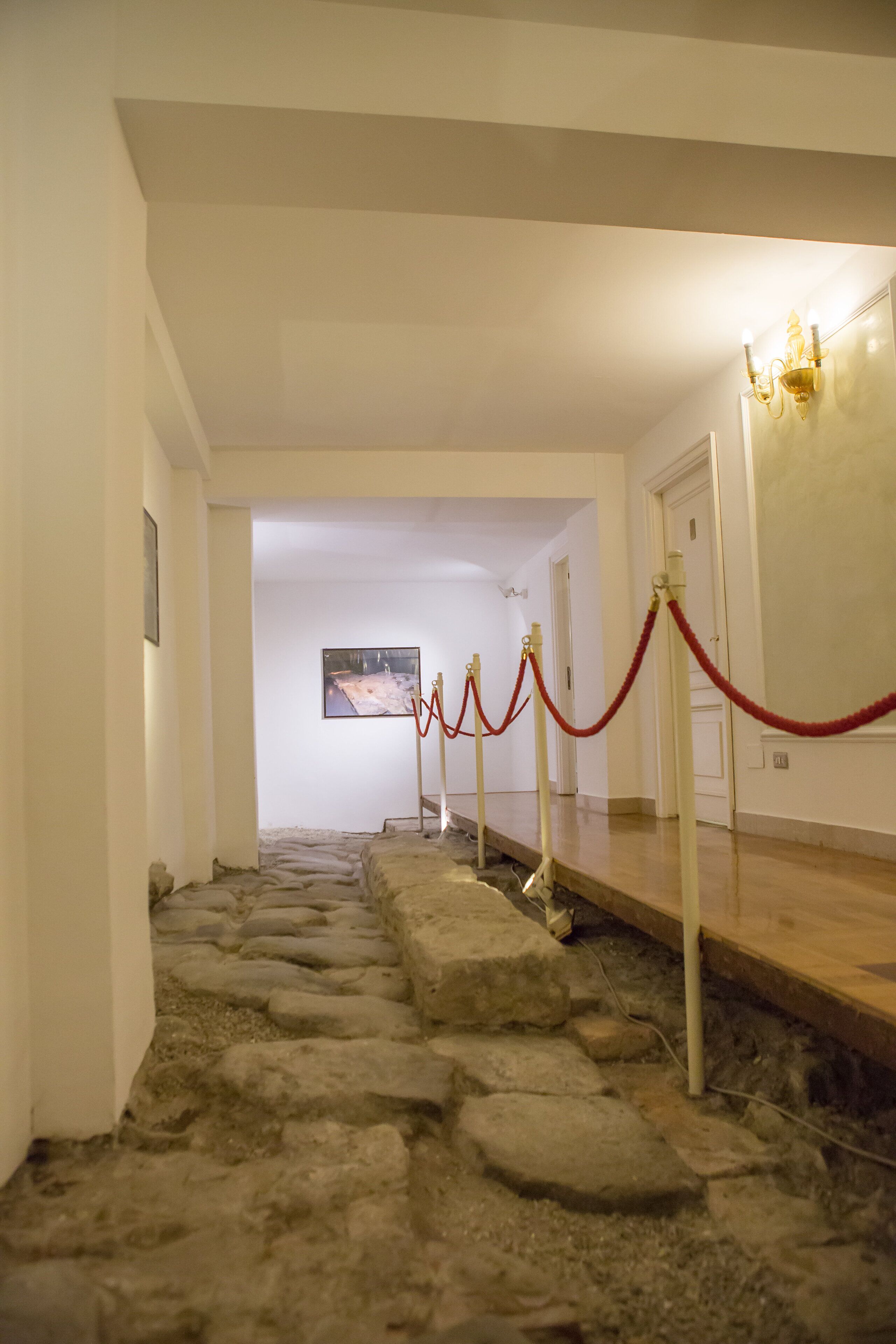 Un pasillo con suelo de piedra que conduce a una puerta.