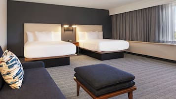 Una habitación de hotel con dos camas, un sofá y una mesita.