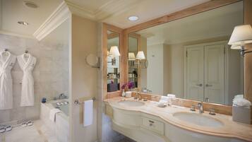 Un bagno con due lavandini, uno specchio grande e una vasca da bagno.