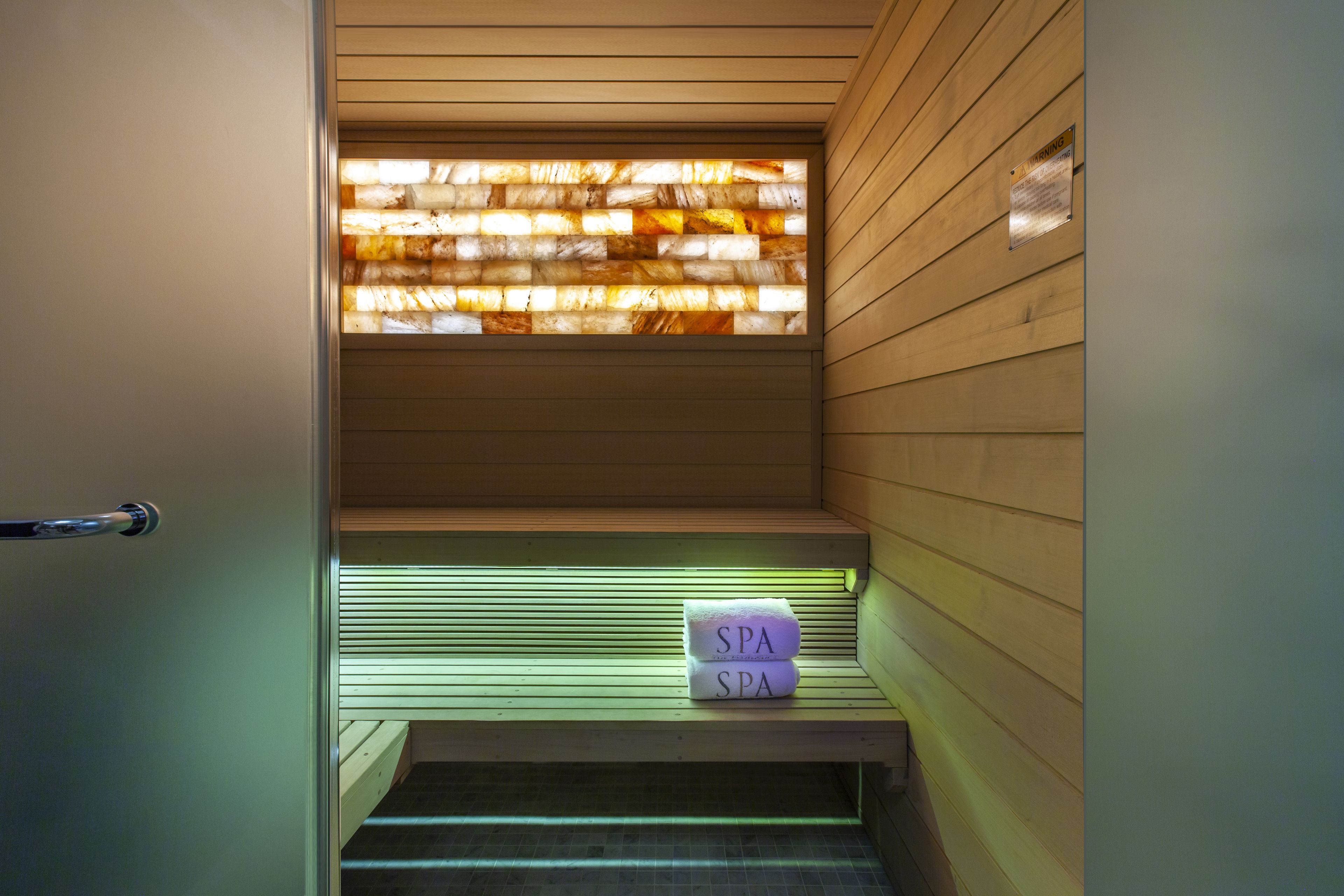 A spa area with wooden paneling, a bench, and a sign indicating 'SPA'.