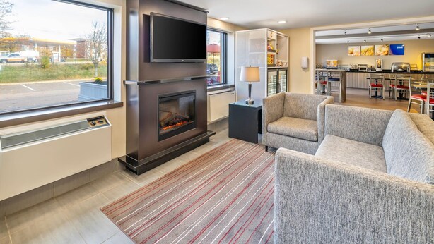 Ein modernes Wohnzimmer mit Kamin, Flachbildfernseher und bequemer Couch.