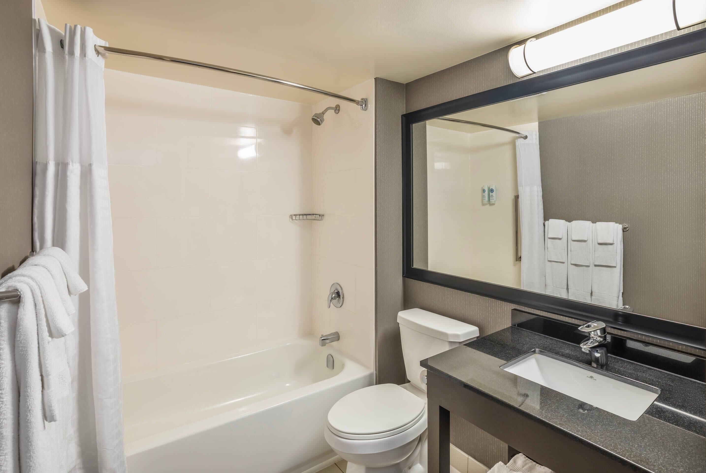A modern bathroom with a bathtub, toilet, and sink.