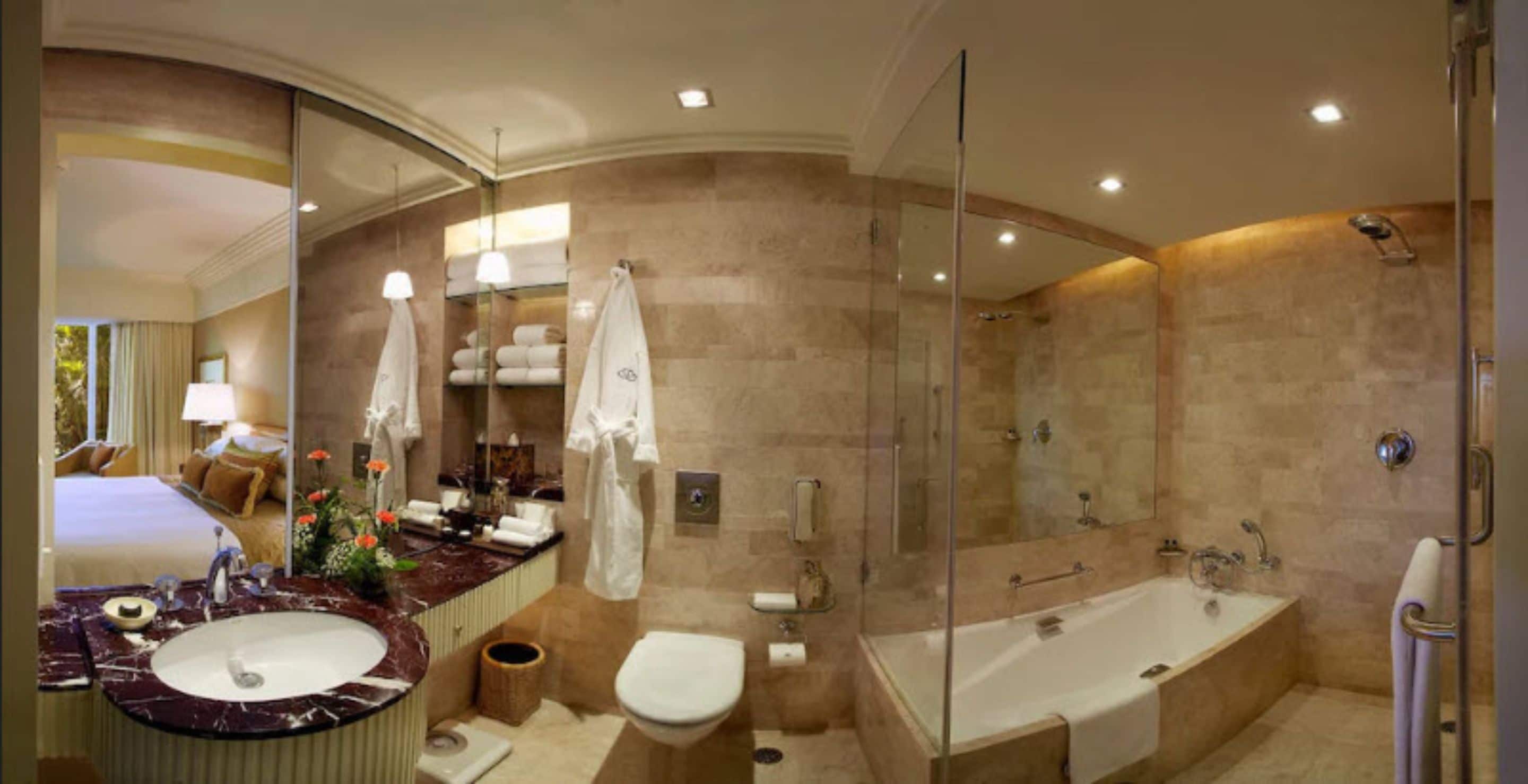 Un baño moderno con un espejo grande, una bañera, un inodoro y un lavabo.