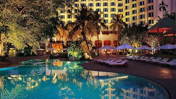 Una piscina al aire libre, sombrillas, tumbonas