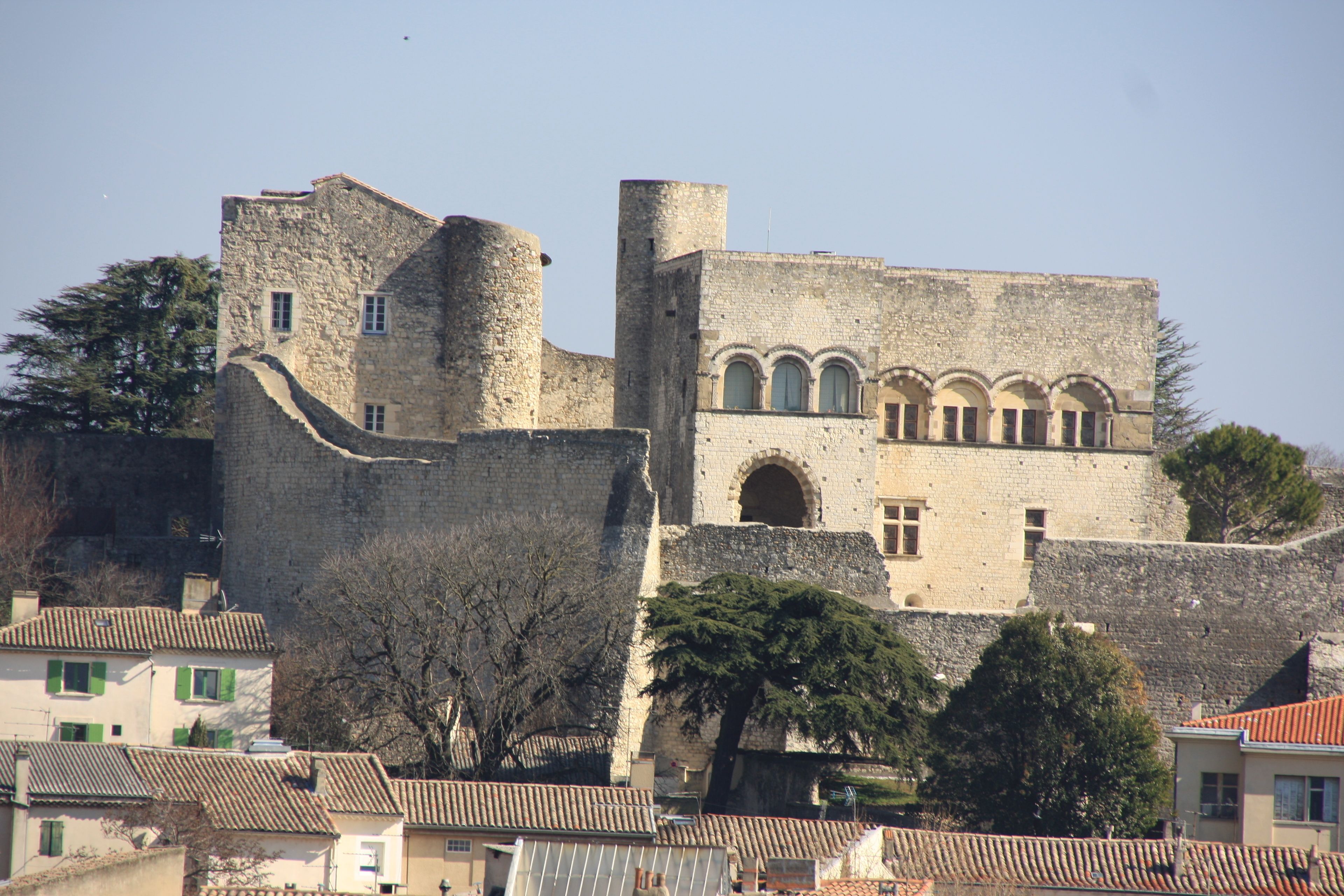 Un edificio histórico de piedra con ventanas arqueadas y una torre.