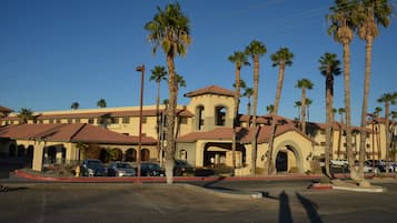 A hotel with a Mediterranean architectural style, featuring arched doorways and a central courtyard.