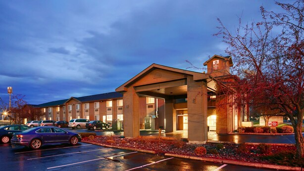 A hotel with a covered entrance, a parking lot, and a sign indicating it is a Best Western Plus. - Best Western Plus Rama Inn & Suites (La Grande)
