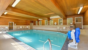 A swimming pool with a wooden ceiling, a lifeguard chair, and a sunshade. - Best Western Plus Rama Inn & Suites (La Grande)