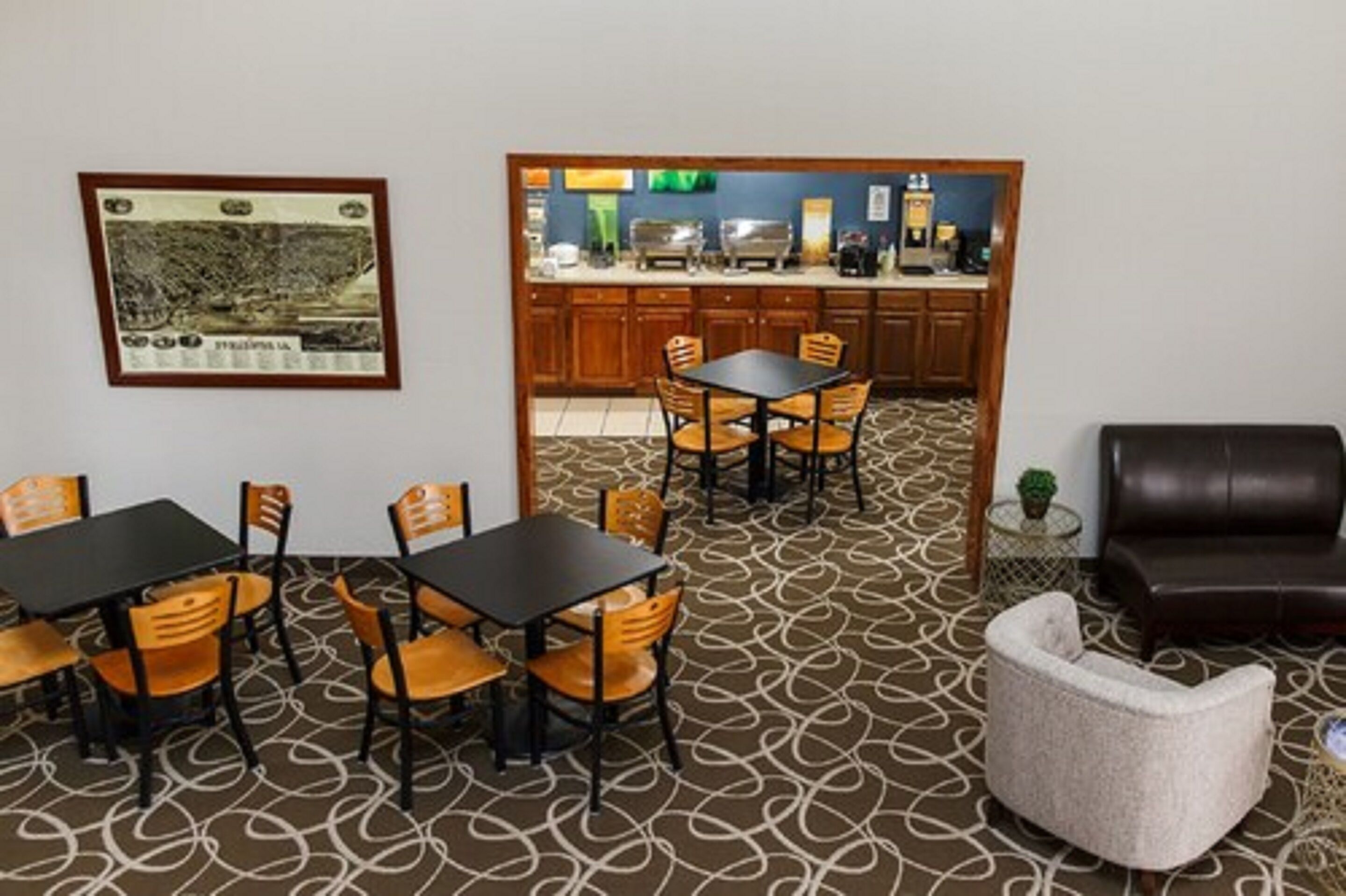 Una habitación con zona de comedor que incluye una mesa, sillas, un sofá, una pequeña mesita auxiliar y un cuadro en la pared.