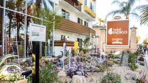 A hotel with a sign indicating 'Hotel Indigo Chambers Bar & Bistro' and a landscaped garden with a fountain.
