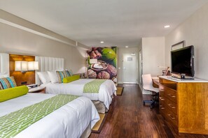A hotel room with two beds, a desk, a television, and a mural on the wall.