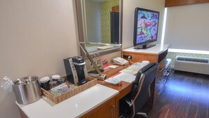 A hotel room with a wooden desk, a computer, a coffee maker, a telephone, and a window with a view of the outside. - Hotel Indigo Anaheim by IHG (Anaheim)