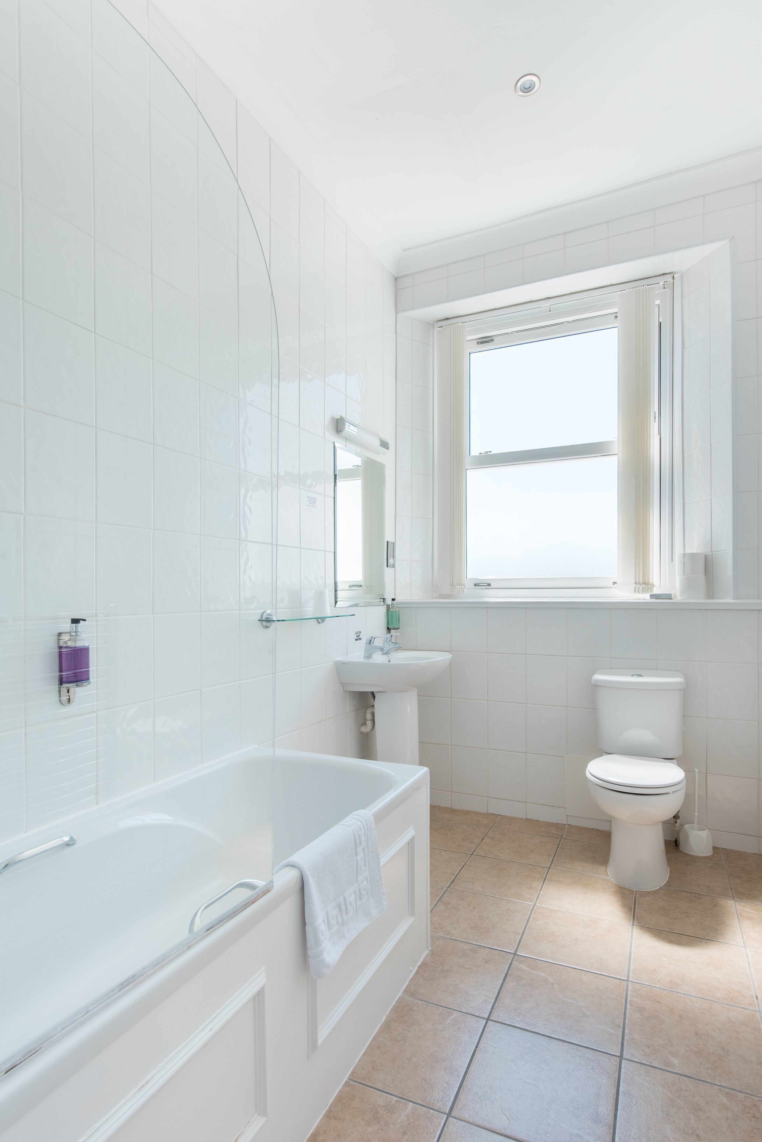 A modern bathroom with a bathtub, sink, and toilet.