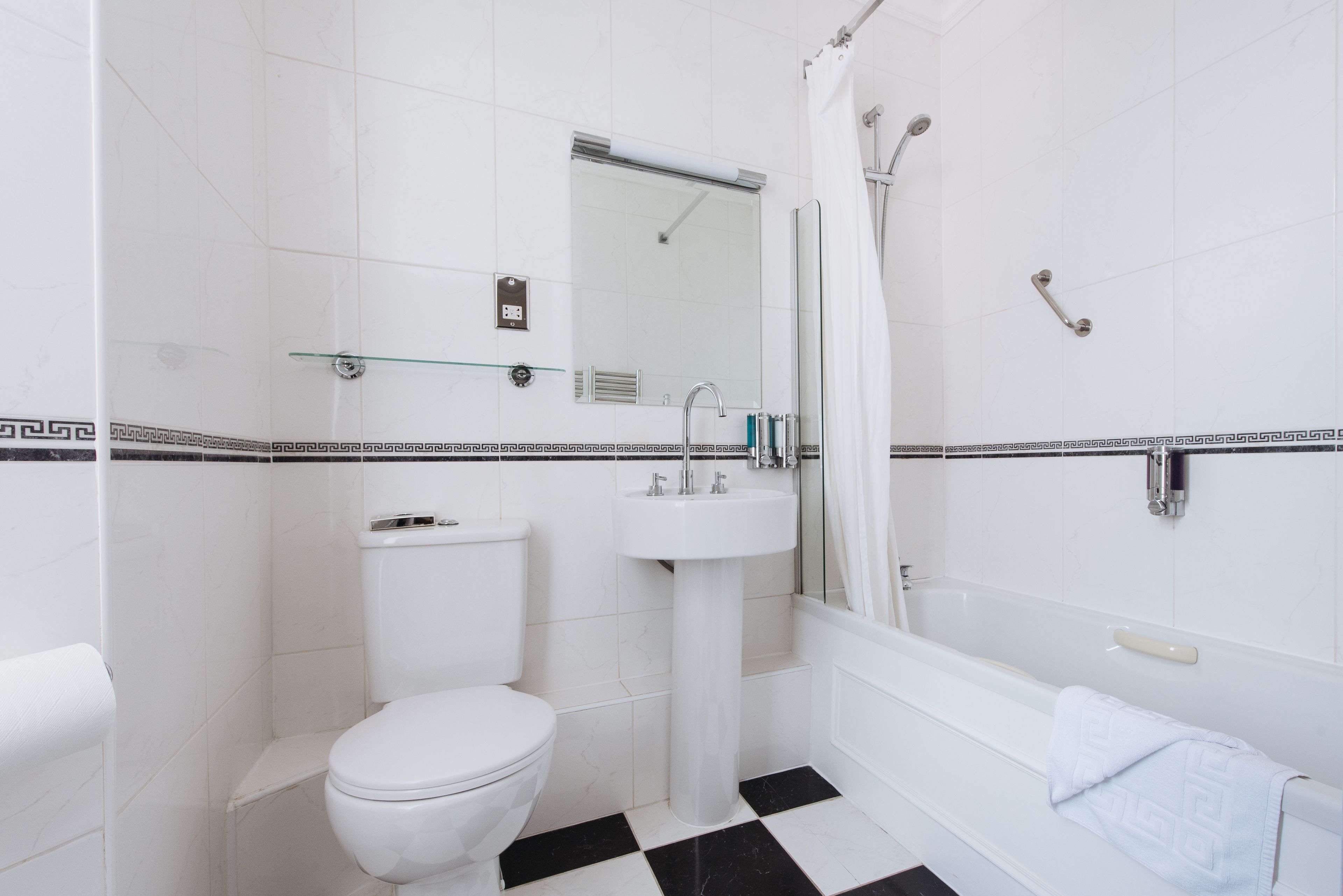Een badkamer met toilet, wastafel en bad.
