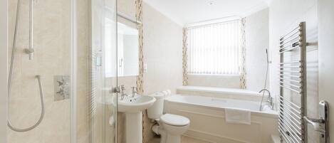 A modern bathroom with a shower, sink, toilet, and bathtub.