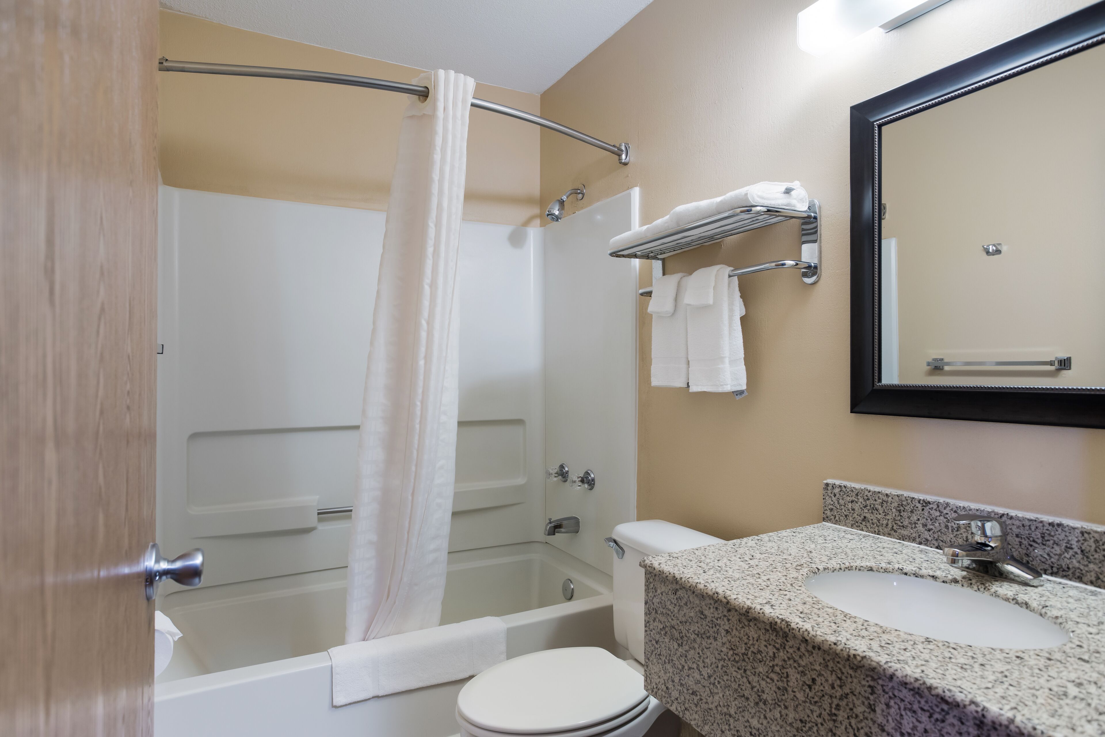 Un baño con bañera, inodoro, lavamanos y cortina de ducha.
